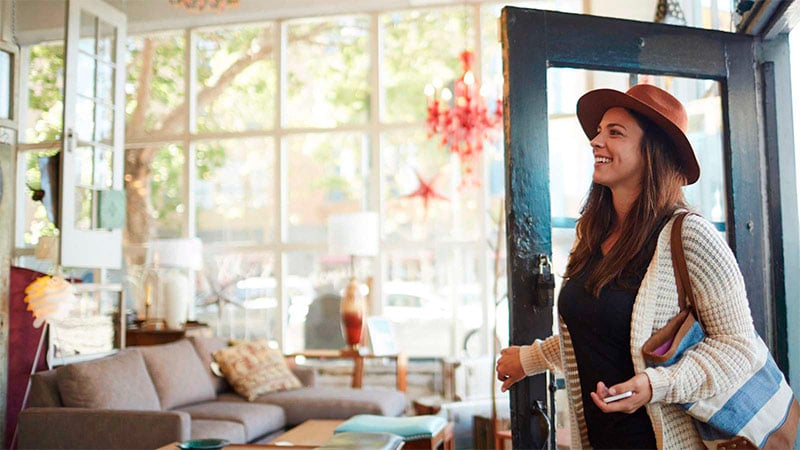 Mujer sonriendo entrando a un local