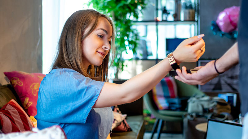 Young woman paying with Visa wereable