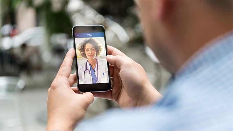 Hombre realizando una consulta a Visa Médico Online desde su celular